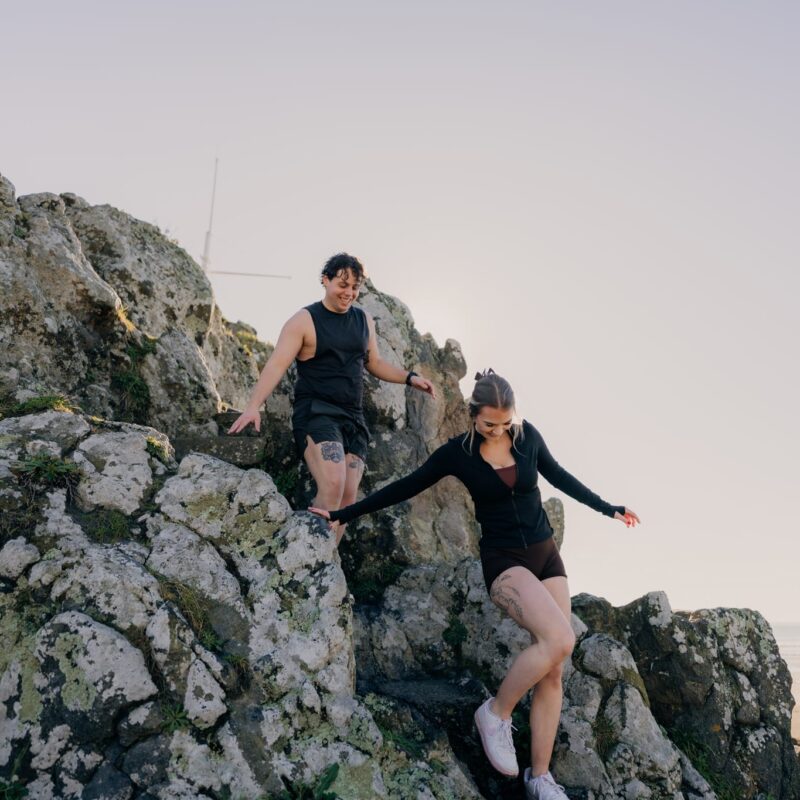 Couple exploring rock formation at beach near Sumner Bay Motel in Christchurch
